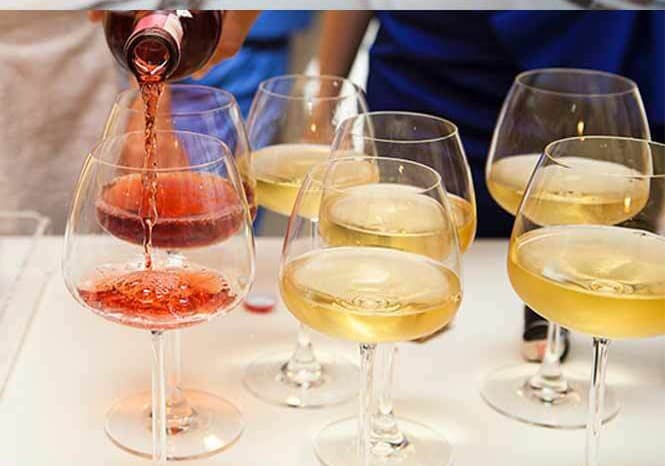 Rosé being poured beside glasses of white wine
