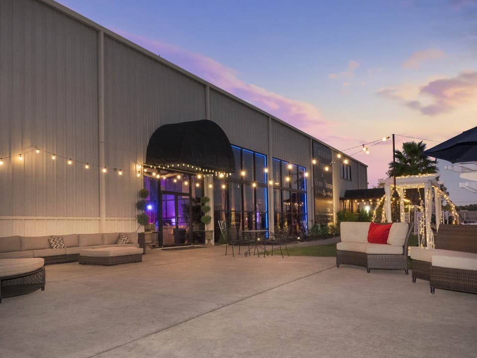 The Embassy Events patio at dusk with string lights and lounge seating